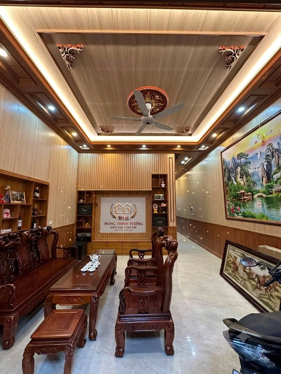 Thiết kế nội thất phòng khách sang trọng với bộ bàn ghế gỗ gụ chạm khắc tinh xảo và hệ trần gỗ giật cấp có đèn LED từ Hưng Thịnh Vượng.